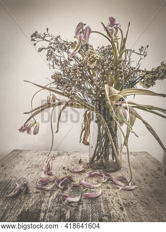wilted flowers bouquet in a clear glass vase ,Vintage filtered
