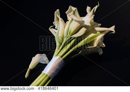 Wedding Bouquet Of White Calla Lilies On A Black Background.