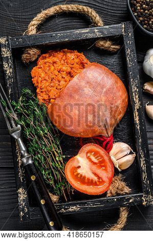 Mallorcan Sobrassada Cured Pork Meat Sausage In A Wooden Tray. Black Wooden Background. Top View