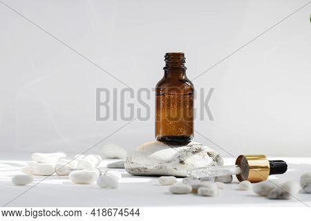 Mock Up Of An Open Glass Dropper Bottle On A Stone Podium On A White Gray Background With Hard Shado