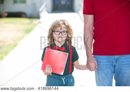 Kid Nerd. School, Family, Education And Outdoor Concept. Parent Holding Hand Of Son With Backpack Ou