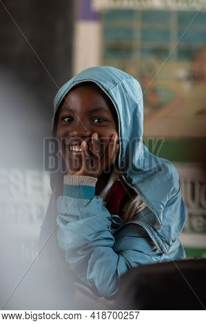 Mzuzu, Malawi. 30-05-2018. Beautiful Portrait Of A Smiling Black Girl In A Blue Jacket Attending Cla