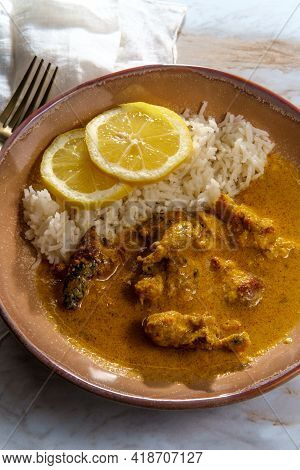 African Chicken Curry Also Known As Kuku Paka, Served With Rice And Sliced Lemon
