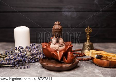 Statuette Of Buddha Incense Sticks At Workplace. Abstract Picture Of A Modern Interior In Oriental S