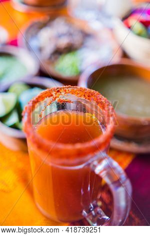 Traditional Mexican Michelada In Glass Mug With Blurry Background