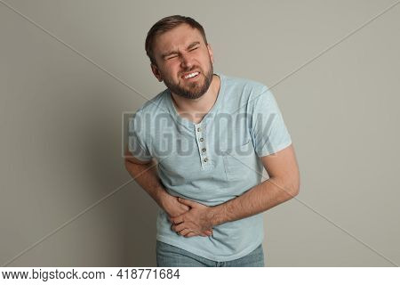 Man Suffering From Acute Appendicitis On Light Grey Background
