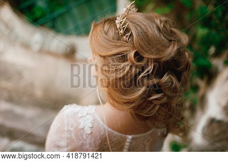 A Fair-haired Bride With A Tiara And A Feminine Hairstyle Stands Near A Beautiful Old Building In Th