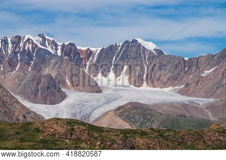Atmospheric Mountain Scenery With Big Beautiful Glacier And Sharp Rocks Under Blue Cloudy Sky. Sceni