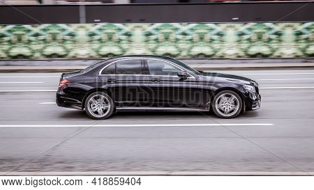 Fast Moving Black Car With Motion Blur Effect. Overspeed In City Concept. Modern Mercedes C Class Au