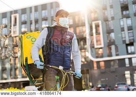Kiev, Ukraine - April 28, 2021: Glovo Bike Courier On The Street. Delivery Boy Of Glovo Delivery Ser