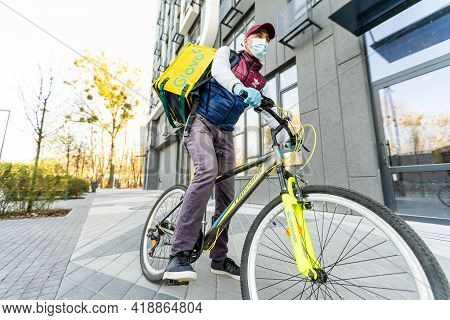 Kiev, Ukraine - April 28, 2021: Glovo Bike Courier On The Street. Delivery Boy Of Glovo Delivery Ser