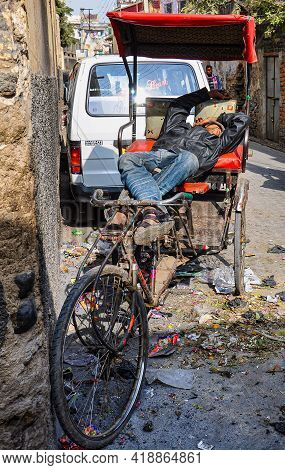 Ajmer, India - Jan 04, 2020: Sleeping Rickshaw Driver Near The Entrance Gate Of Dargah Shariff. Darg