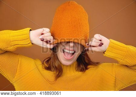 A Portrait Of A Cheerful Happy Girl With Light Brown Long Hair Having Fun, Covering Her Eyes With A 