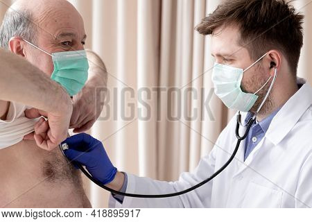 Caucaian Male Doctor Listening To A Senior Males Breathing With A Stethoscope