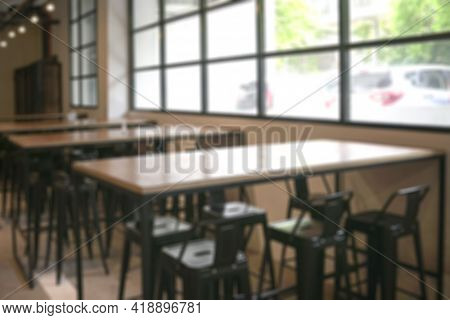 Empty Cafetaria With Wooden Tables And High Chairs, And Windows With A View Of Outside. Defocused.