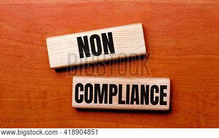 On A Wooden Table Are Two Wooden Blocks With The Text Question Non Compliance