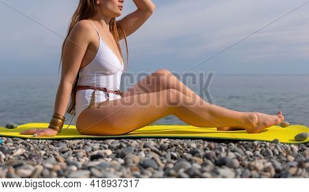Young Woman In White Swimsuit With Long Hair Practicing Stretchi