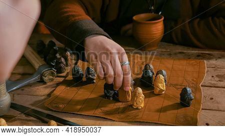 Close Up Shot - Two Men In Russian Ethnic Suit Playing Medieval Popular Strategy Board Game - Tafl. 