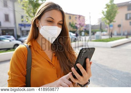Smiling Girl With Mask Checking Her Phone On Street