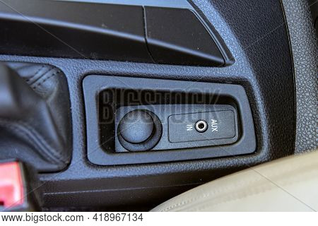 Auxilary Input Jack For 1/8 Inch Plug Is Modern Convenience On The Center Console Of Automobile.
