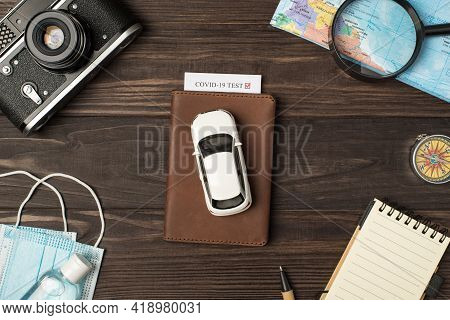 Top View Photo Of Car Model On Leather Passport Cover With Covid Test Camera Map Magnifier Compass N