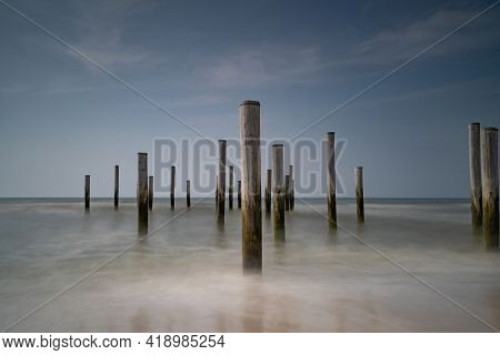 Long Exposure Seascape. Taken At The North Sea In Petten With The Pole Village In The Sea, Blue Sky,