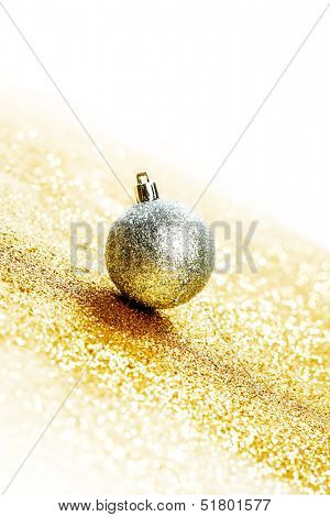 Silver christmas ball on shiny golden background