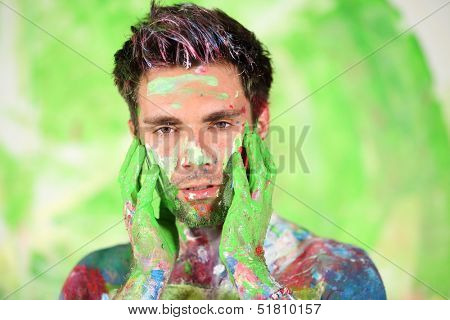 Whole painted young man with hands near face