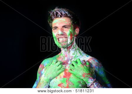 Man bares his teeth all in paint in the studio
