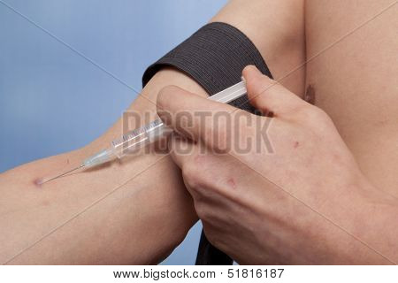 Drug addict man with syringe in action