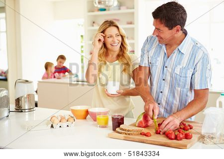 Parents Preparing Family Breakfast In Kitchen