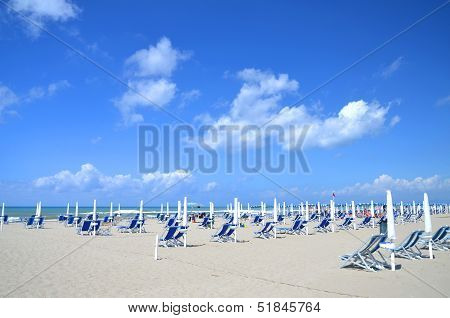 Beach umbrellas and chairs on beautiful beach Marina di Vecchiano nearby Pisa, Tuscany in Italy
