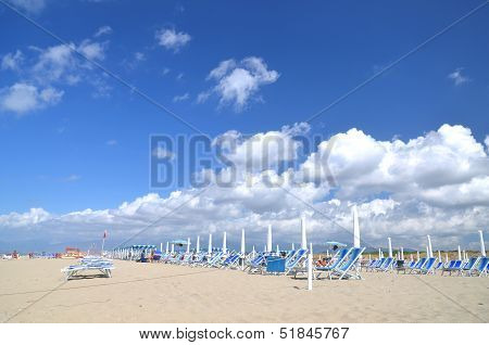 Beach umbrellas and chairs on beautiful beach Marina di Vecchiano nearby Pisa, Tuscany in Italy