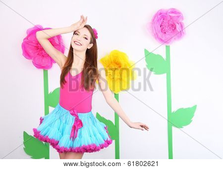 Beautiful young woman in petty skirt on decorative background