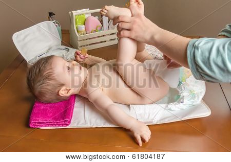 Mother Changing Diaper Of Adorable Baby