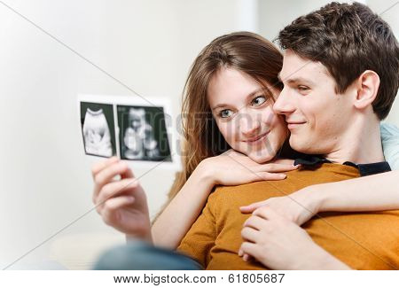 Beautiful Couple Watching With Emotion Ultrasound Pictures Of Their Baby