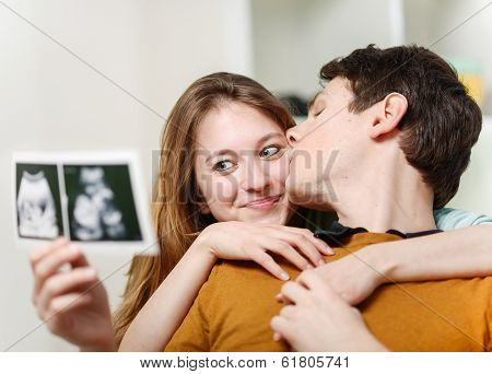 Beautiful Couple Watching With Emotion Ultrasound Pictures Of Their Baby