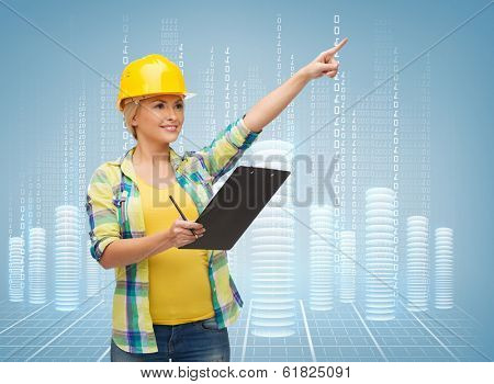 repair, construction and maintenance concept - smiling woman in helmet with clipboard pointing finger