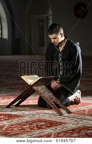 Muslim Man In Dishdasha Is Reading The Quran
