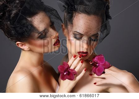Excitement. Two Voluptuous Ladies With Purple Orchid Flowers Flirting