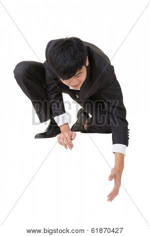 Asian businessman sit and bend down to help somebody, full length portrait isolated on white.