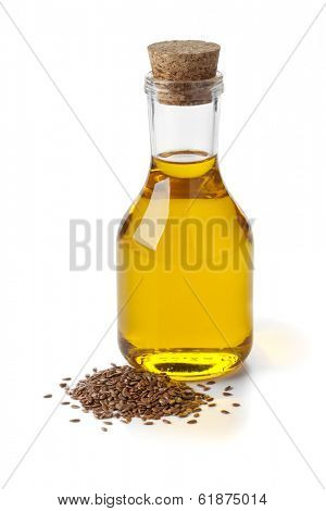 Bottle of flax seed oil ans seeds on white background