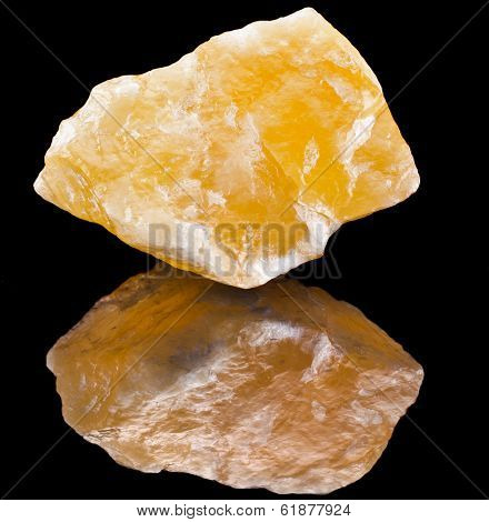 Calcite crystal mineral with reflection on black surface background 