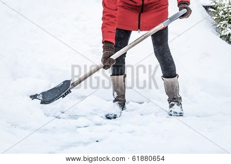 Close-up Of Woman Shoveling Her Parking Lot