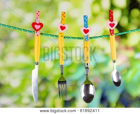 Cutlery dried on rope on natural background