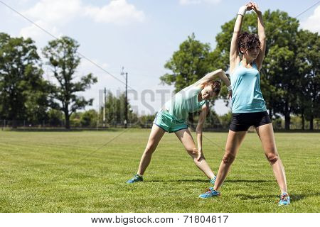 Two Young Girls Stetching Before A Jogging