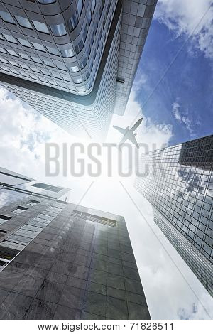 plane flying over a modern glass and steeel office towers in Frankfurt am Main, Germany