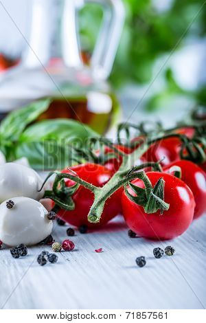 Cherry tomatoes, basil leaves, mozzarella cheese and olive oil for caprese salad.