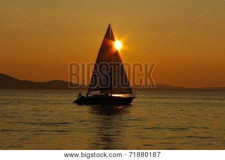 Sailing Into The Sunset With Reflections On The Sea Surface