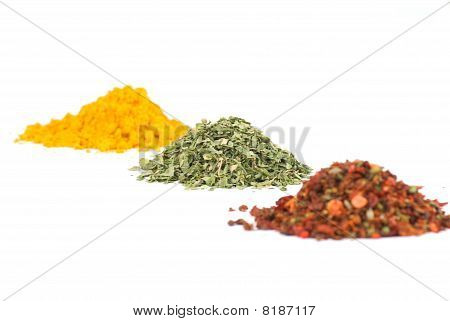 Montes de várias especiarias de chão no fundo branco